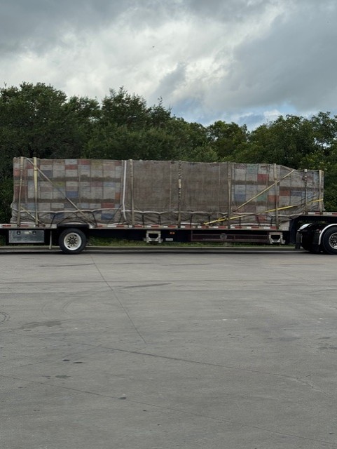 Flatbed trailers loaded with beehives on the road for nationwide delivery